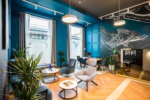 Una camera d'hotel moderna con un'ampia finestra, un'area pranzo e un murale raffigurante un panorama urbano.