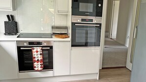 A compact kitchen with a built-in oven, a toaster, and a microwave. - Providing the perfect mix of countryside tranquillity and coastal adventure. (Pinwherry, near Girvan)