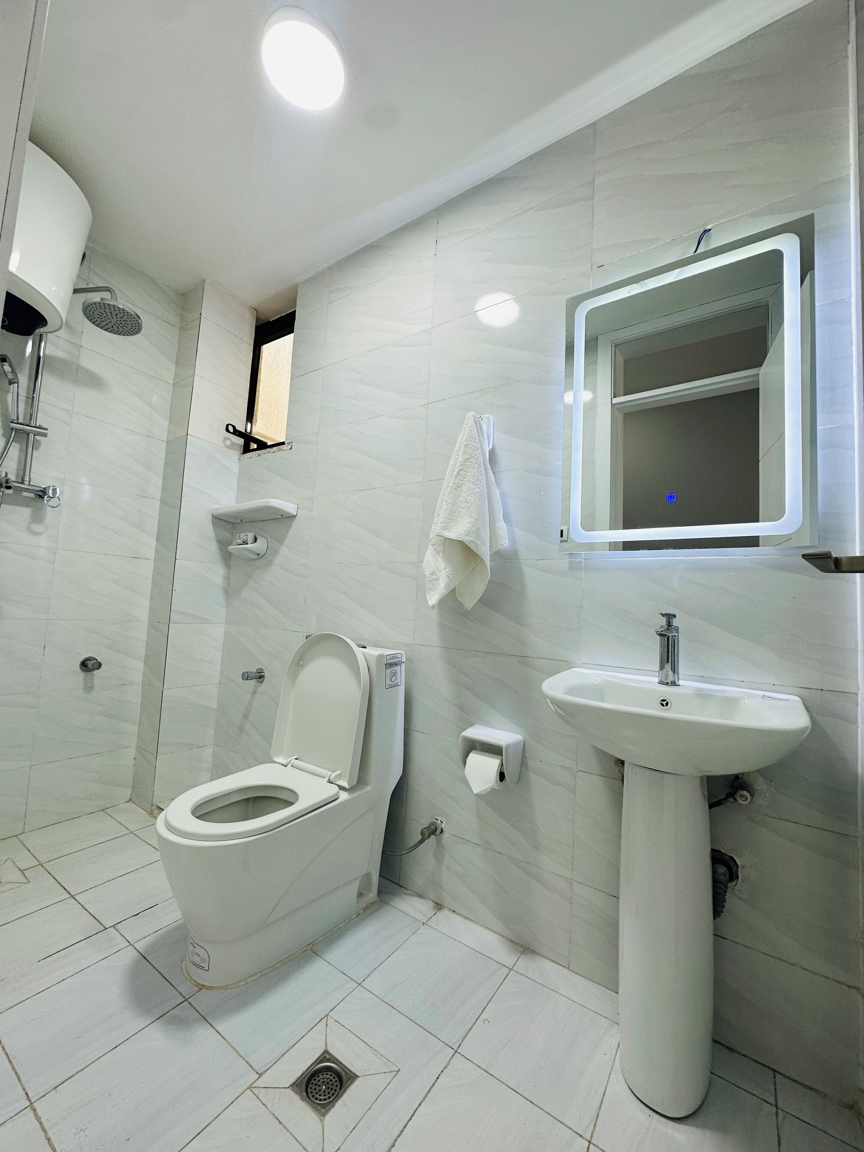 A modern bathroom with a toilet, sink, and shower.