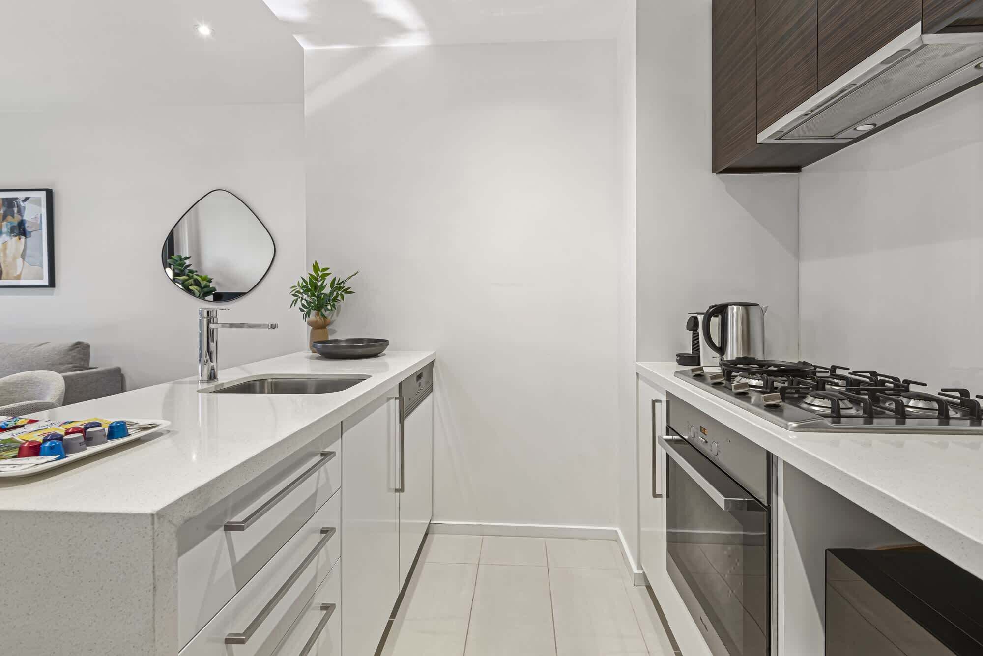 A modern kitchen with a gas stove, a sink, and a countertop.
