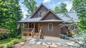A two-story wooden cabin with a porch, a front door, and a small window. - Private 6-Acre Retreat | Views, Hot Tub, Fire Pit (Ellijay)