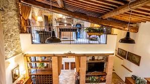 A spacious loft with a high ceiling, exposed wooden beams, a stone wall, and a balcony with a view. - Villa in Santa Firmina with 5 bedrooms sleeps 10 (Santa Firmina)