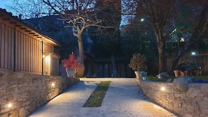 A stone pathway leading to a building with a wooden facade and a potted plant in the center. - Villa in Santa Firmina with 5 bedrooms sleeps 10 (Santa Firmina)
