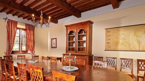 A dining room with a large wooden table, chairs, a chandelier, a cabinet with glass doors, and a map on the wall. - Villa Rama: A splendid seventeenth-century two-story historical villa surrounded by meadows and by green hills, with Free WI-FI. (Gambassi Terme)