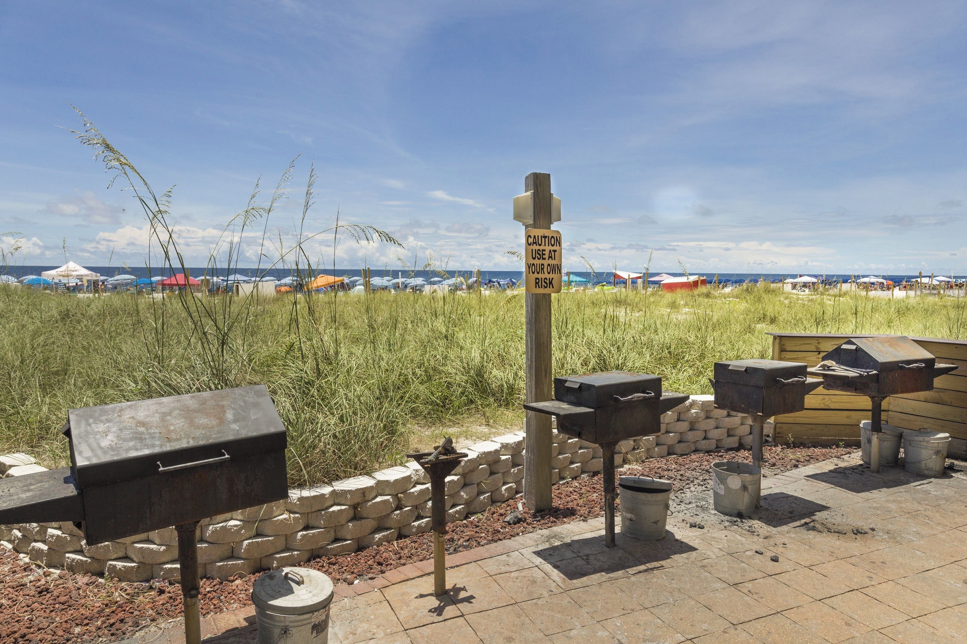 Een barbecueplaats met grills en een waarschuwingsbord.