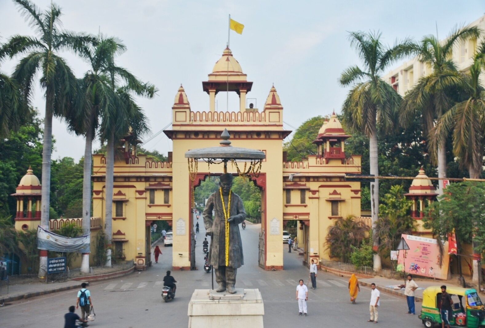 A large, ornate building with a central archway and a flag on top.