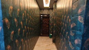 Ένας διάδρομος με διακοσμημένους τοίχους και μαρμάρινο δάπεδο.