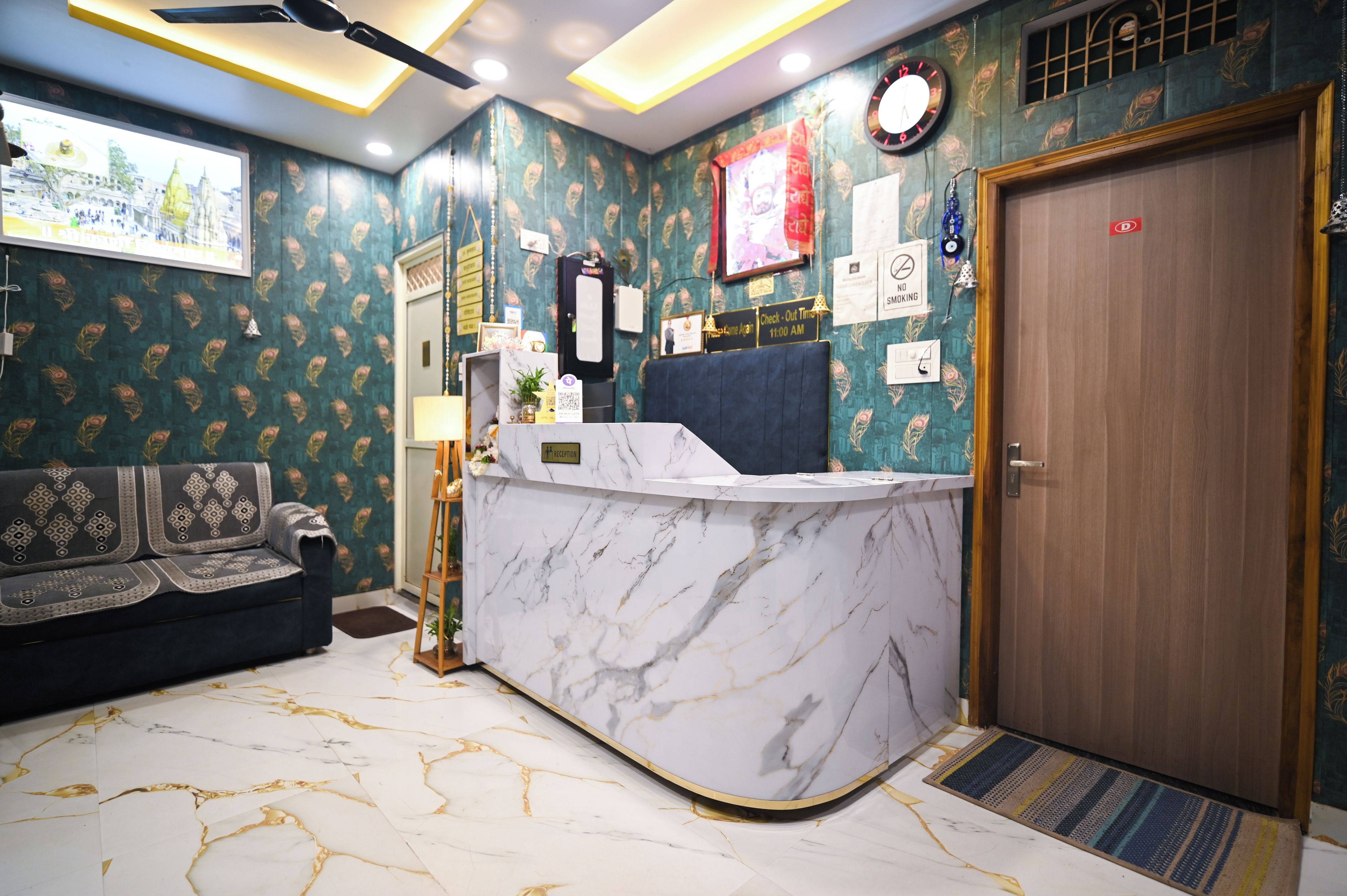 A reception desk with a marble top, a clock, and a door with a red sticker.