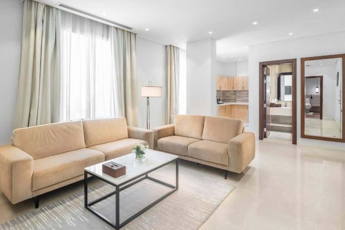 A modern living room with two sofas, a coffee table, and a lamp.