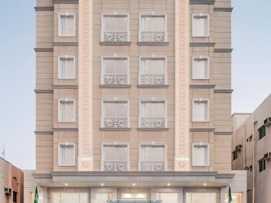 A multi-story hotel with a symmetrical facade, large windows, and a central entrance with a canopy.