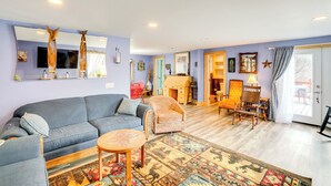 Una sala de estar con sofá, sillón y mesa de centro, un mueble de madera y televisor.