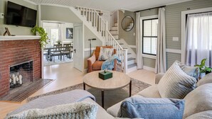 A spacious living room with a fireplace, a staircase, and a comfortable seating area.