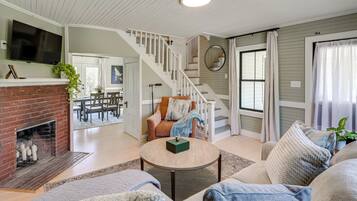 A spacious living room with a fireplace, a staircase, and a comfortable seating area.