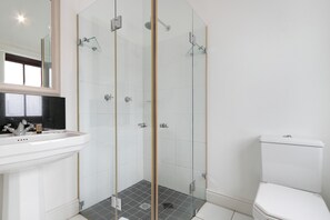 A modern bathroom with a glass-enclosed shower, a white sink, and a toilet. - Winelands Golf Lodges 10 (Cape Town)