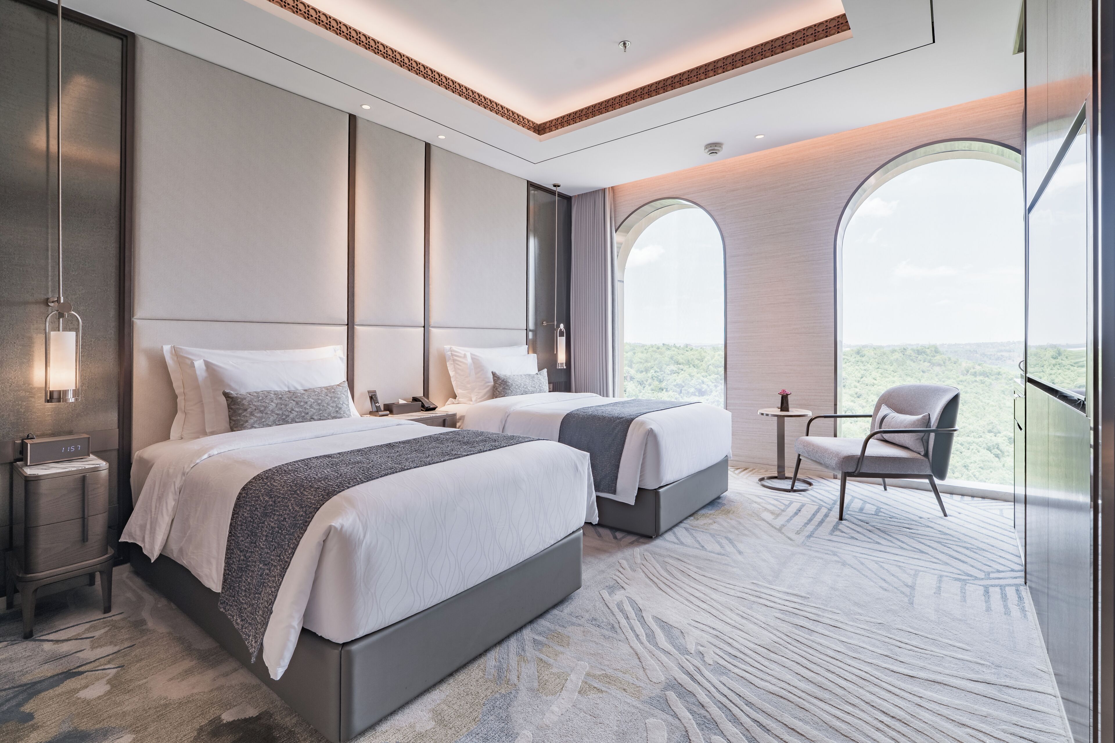 Una habitación de hotel moderna con dos camas, una mesita y una silla.