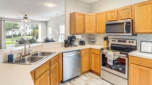 A modern kitchen with wooden cabinets, stainless steel appliances, and a dishwasher.