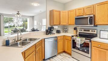 A modern kitchen with wooden cabinets, stainless steel appliances, and a dishwasher.