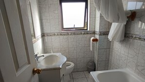 Un baño con inodoro, lavabo, bañera y ventana.