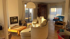 A spacious living room with a large sofa, a wooden coffee table, and a blue armchair. - House near Montpellier quiet and bright swimming pool (Laverune)
