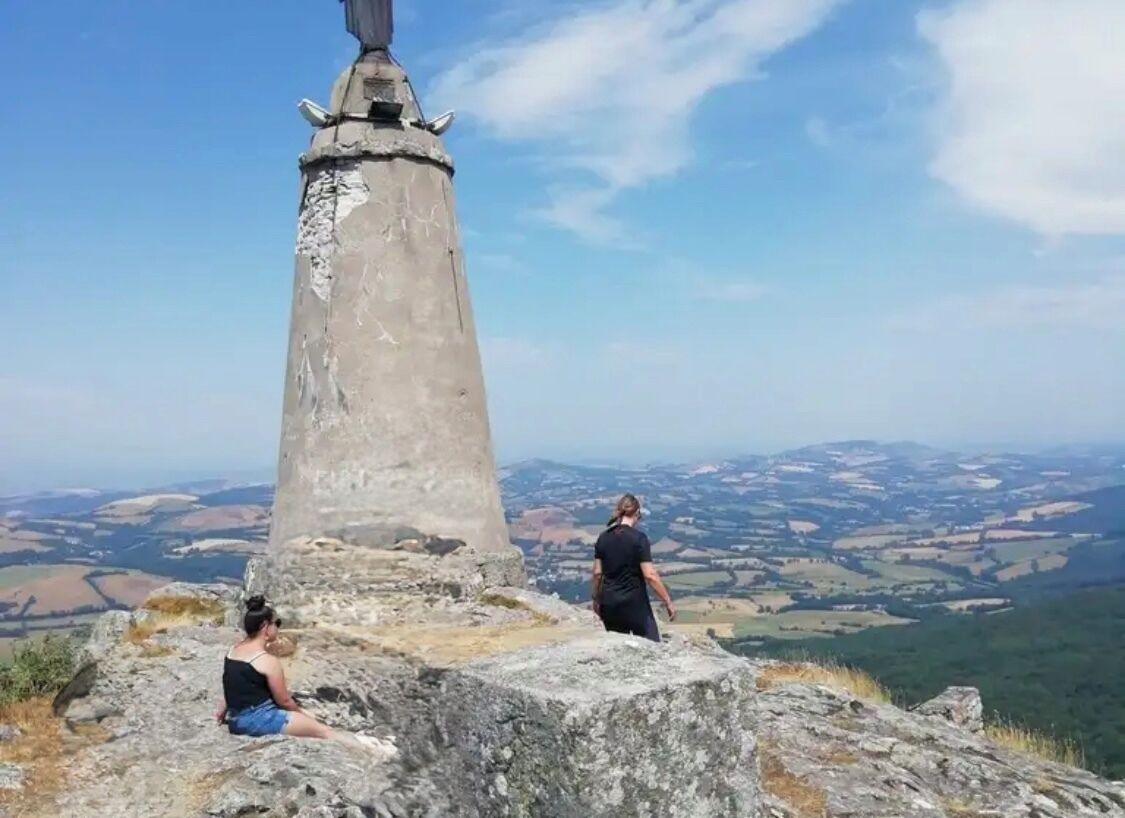 A stone monument with a clear view of a valley below.