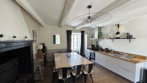 A modern kitchen with a wooden table, chairs, and a hanging light fixture. - MAGNIFICENT Gîte for 4 to 10 people in NAGES 81/LAC DU LAOUZAS/HAUT LANGUEDOC (Nages)