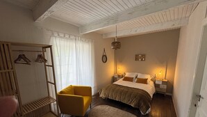 A bedroom with a bed, a chair, a bedside table, a lamp, and a hanging light fixture. - MAGNIFICENT Gîte for 4 to 10 people in NAGES 81/LAC DU LAOUZAS/HAUT LANGUEDOC (Nages)