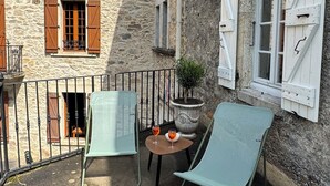 A courtyard with two lounge chairs, a small table with drinks, and a potted plant. - MAGNIFICENT Gîte for 4 to 10 people in NAGES 81/LAC DU LAOUZAS/HAUT LANGUEDOC (Nages)