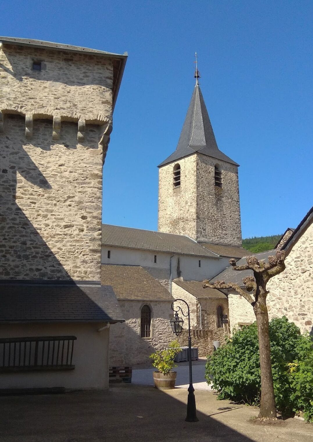 A historic stone building with a prominent tower and a smaller adjacent structure.