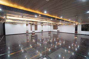 A spacious, well-lit room with a polished floor, multiple air conditioning units, and ceiling fans. - HOTEL ROSHAN (Varanasi)