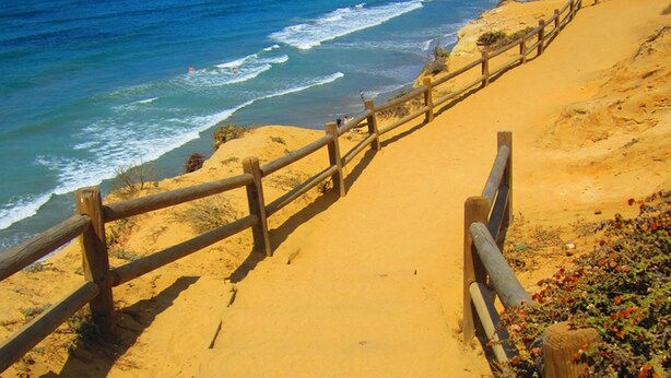 A sandy beach with a wooden walkway leading to the ocean. - Lovely 2/2 with optional 3rd bedroom condo one exit from the Del Mar Racetrack (San Diego)