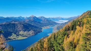A mountainous landscape with a lake and forested areas.