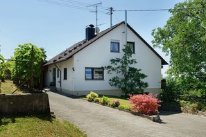 Eingeschossiges Haus mit geneigtem Dach, Schornstein und Satellitenschüssel.