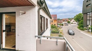 Ein Wohngebäude mit Balkon, Straßensicht und blauem Himmel.