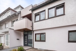 A modern residential building with a flat facade, large windows, and a small balcony. - Holiday Apartment "Apartment Am Wasen" with Balcony (Kirchheim unter Teck)