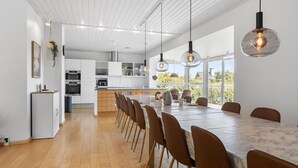 A modern kitchen with white cabinets, a central island, and pendant lighting.