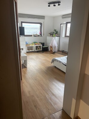 Une chambre à coucher comprenant un lit, un bureau, une chaise, un radiateur et une fenêtre.