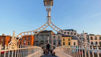 A pedestrian bridge with ornate metal railings and a street lamp.