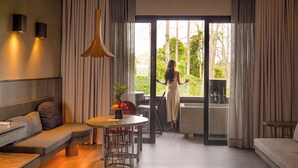 Ein modernes Interieur mit einer Couch, einem Esstisch und Blick auf Grünflächen.