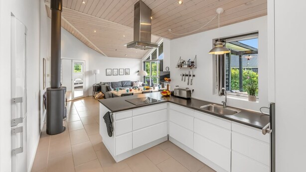 A modern kitchen with white cabinets, a large island, and a built-in stove. - "Smilla" - 1.1km from the sea by Interhome (Hals)