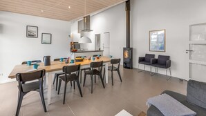 A modern kitchen with a central island, a dining area with chairs, a sofa, and a fireplace. - "Smilla" - 1.1km from the sea by Interhome (Hals)