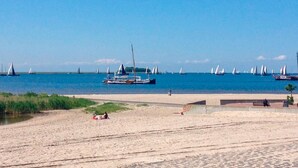 Ein Strand mit Booten und blauem Himmel.