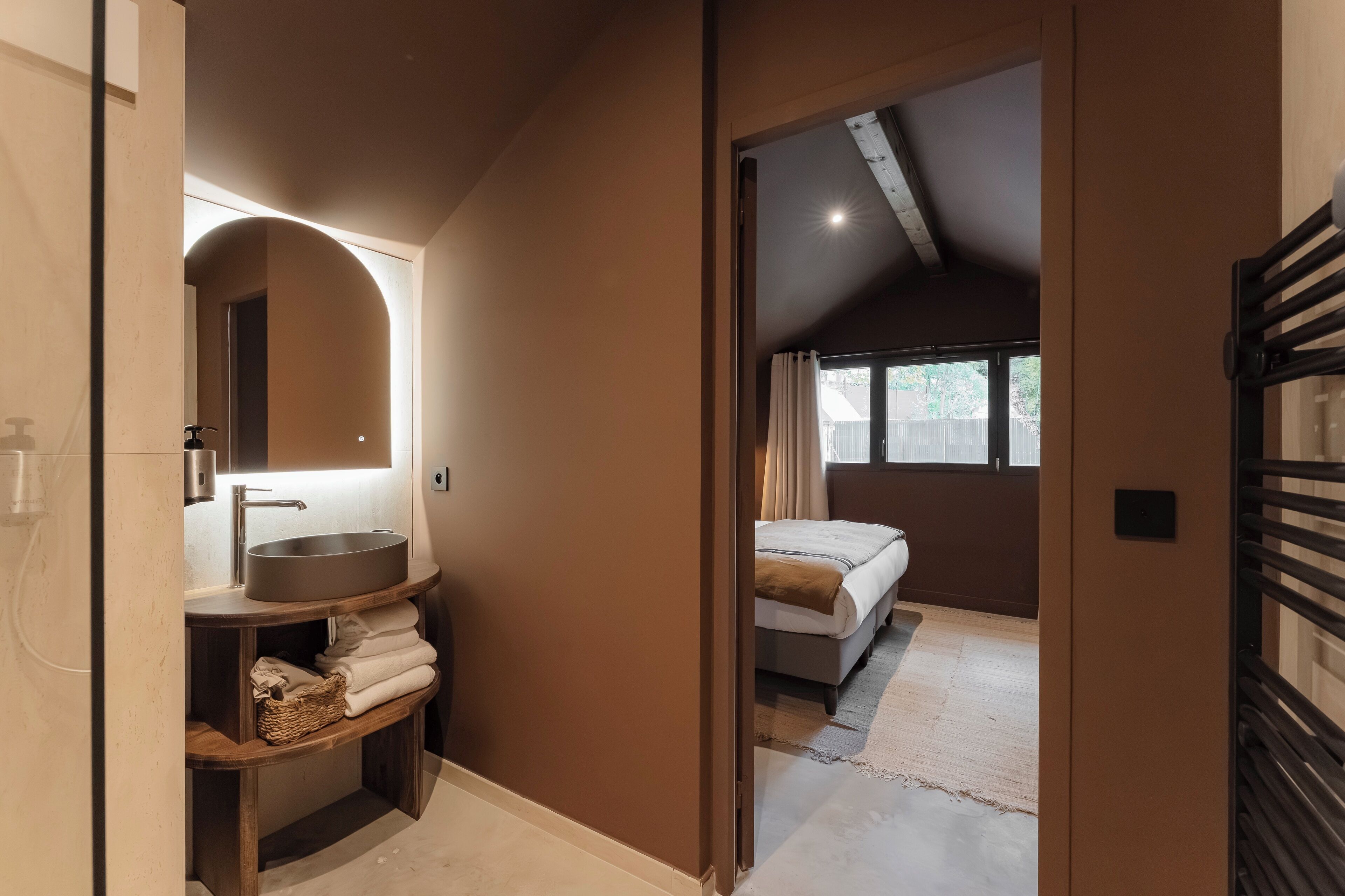 A modern bathroom with a large sink, mirror, and wooden shelves.