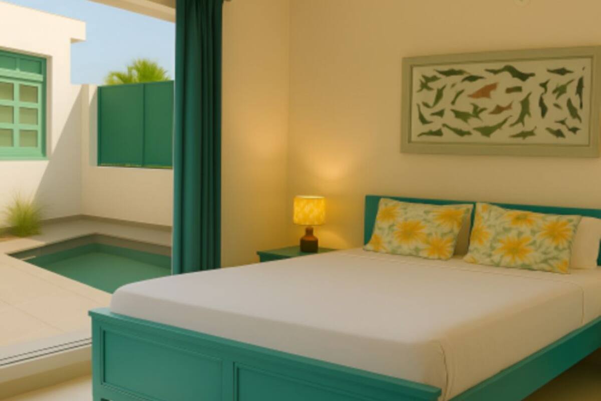 A bedroom with a bed, a nightstand, a lamp, a painting, and a small pool.