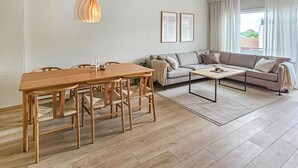 A modern living room with a wooden dining table, a sofa, and a coffee table. - 4 bedroom beautiful apartment in Oslo (Oslo)