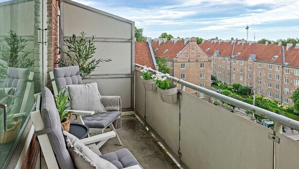 A balcony with a seating area, potted plants, and a view of surrounding buildings. - 4 bedroom beautiful apartment in Oslo (Oslo)