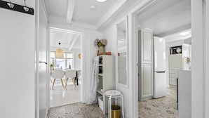 A hallway with a patterned floor, white walls, and a dining area with a table and chairs. - Nice home in Tvedestrand with WiFi (Tvedestrand)
