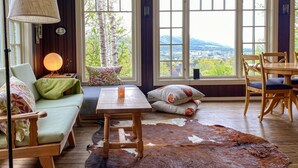 A cozy living room with a sofa, a wooden table, and a cowhide rug.