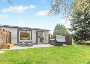 A modern house with a patio, outdoor seating, and a TV. - 1 bedroom accommodation in Faringdon (Faringdon)