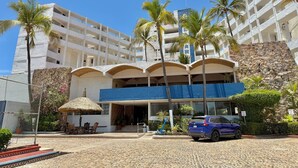 A hotel with multiple floors, a covered entrance, and a blue awning.
