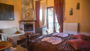 A cozy room with a fireplace, a bed with a quilt, a sofa, and a table with a plate and a vase.